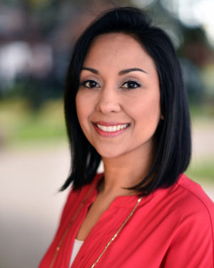 A woman in red shirt smiling for the camera.